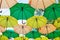 Green and yellow umbrellas hanging above city streets. Colorful umbrellas in sky. Street decoration. Street with colorful umbrella
