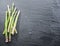 Green young asparagus sprouts on the black background