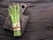 Green young asparagus sprouts on wooden table. Top view