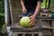 Green young fresh coconut cutting with heavy chop knife