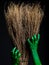 Green zombie hands with a broom. Halloween Theme