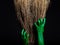 Green zombie hands with a broom. Halloween Theme