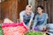 Greengrocer couple smiles as they put together a vegetable display at a vegetable stall