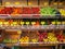 Greengrocer inside a shop. Fruit exposed on shelves, variety of colors.