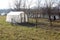 Greenhouse with small garden next to river on cold winter day