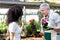 Greenhouse worker giving a flower pot