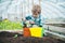 Greenhouse worker. small boy greenhouse worker. greenhouse worker planting flowers. greenhouse worker little boy care