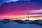 Greenlandic sunset sky with antenna and rocks with snow in the f