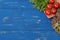 greens and tomatoes on a cutting board. ingredients for cooking. On a blue wooden table with a place for inscription