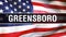 Greensboro city on a USA flag background, 3D rendering. United states of America flag waving in the wind. Proud American Flag