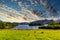 Greeny shoreline of Derwentwater lake under a cloudy sky