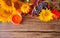 Greeting autumn card with copy space. Composition with pumpkin, autumn leaves, grape, sunflower, candle and berries on the wooden