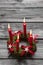 Greeting card: Four red burning advent candles on wooden grey ba