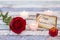 Greeting card with Happy Valentine`s Day text, red rose, gift box, and candles