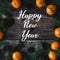 Greeting card with the inscription Happy New Year on a wooden background with fir branches tangerines