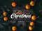 Greeting card with the inscription Merry Christmas on a wooden background with fir branches tangerines