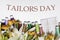 Greeting card with multi-colored threads and the text Tailors Day. For the holiday of a seamstress, tailor, atelier