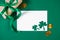 Greeting card for St. Patricks Day on a green background. Gold coins, shamrock and gift. Happy Irish holiday