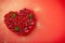 Greeting card with Valentine`s Day. confectionery Raspberry tart with mint in the form of a heart, lies on a red background