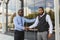 Greeting and handshake of two afro american businessmen partner against the backdrop of a modern building exterior