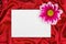 Greeting paper card and flower on red cloth