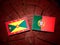 Grenada flag with Portuguese flag on a tree stump isolated
