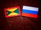 Grenada flag with Russian flag on a tree stump