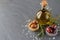 Grey abstract background with glass jar with olive oil and bowls with olives, sea salt and olive branch.