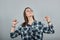 On grey background confident in glasses woman points fingers at herself