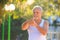 Grey Bearded Old Man in Vest Stretches Fingers in Park