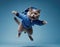 grey British cat jumping on a blue background. in ski suit