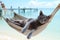 grey cat sprawled on a hammock swaying gently on seaside