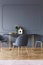 Grey chair at wooden table in minimal dining room interior with