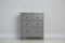 Grey chest of drawers near wall