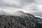 Grey clouds over a steep mountain peak