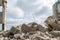 Grey concrete fragments of the Foundation against the background of a destroyed building against the sky. Background