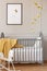 Grey crib, bee decoration and graphic, and rocking horse in a kid room