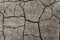 Grey dried and cracked ground earth background. Closeup of dry fissure dark ground. Gray crack on earth texture. erosion