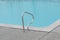 Grey edge swimming pool blue water metal hand railing