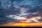 Grey fluffy clouds on sky over hill during sunrise