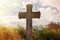 Grey grave stone cross standing alone in Cemetery, blue sky background, sunlight rays