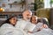 Grey-haired granddad reading bedtime stories to his granddaughters