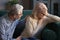 Grey haired husband supporting unhappy mature woman wife at home