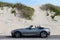 Grey Haired Man in Convertible by Sand Dunes