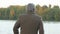 Grey-haired man enjoying beautiful view of autumn trees reflection in calm river