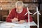 Grey-haired man using protractor while drawing blueprint