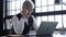 Grey-haired man working on a laptop. Serious mature man in elegant suit typing