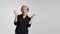 Grey haired mature woman doing a amazement gesture.Pretty mid aged grey haired woman in black shirt isolated on grey