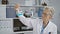 Grey-haired senior woman scientist working and measuring liquid in test tube in indoor laboratory, meticulously ensuring safety