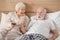 Grey-haired woman and her husband resting at home